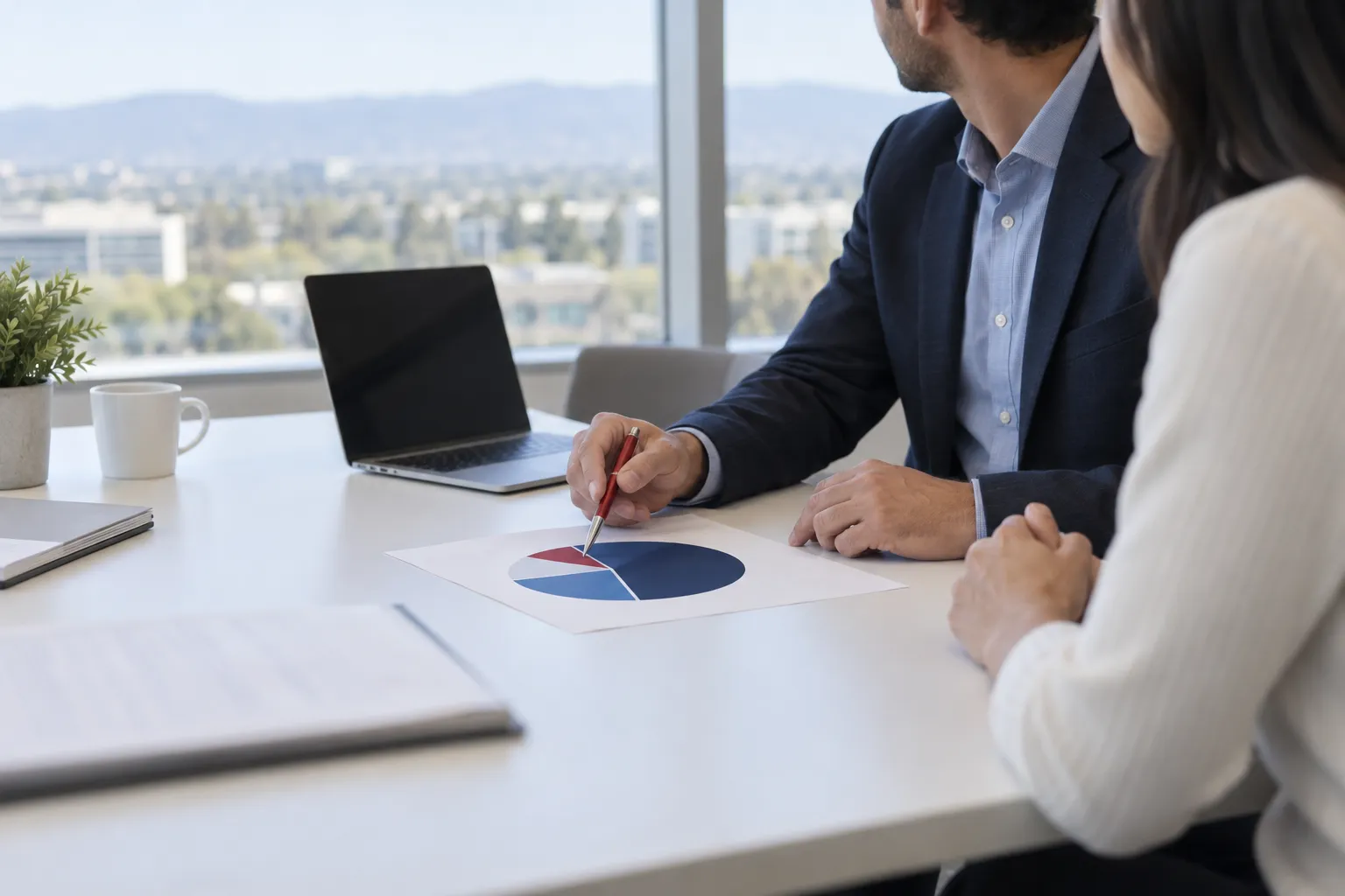 Two business professionals shaking hands across a conference table